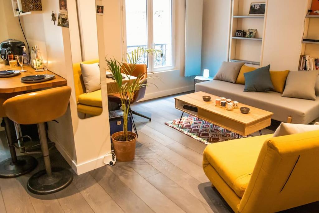 uma sala de estar com um sofá amarelo e uma mesa em Chez Cam - Paris Rooftop em Paris