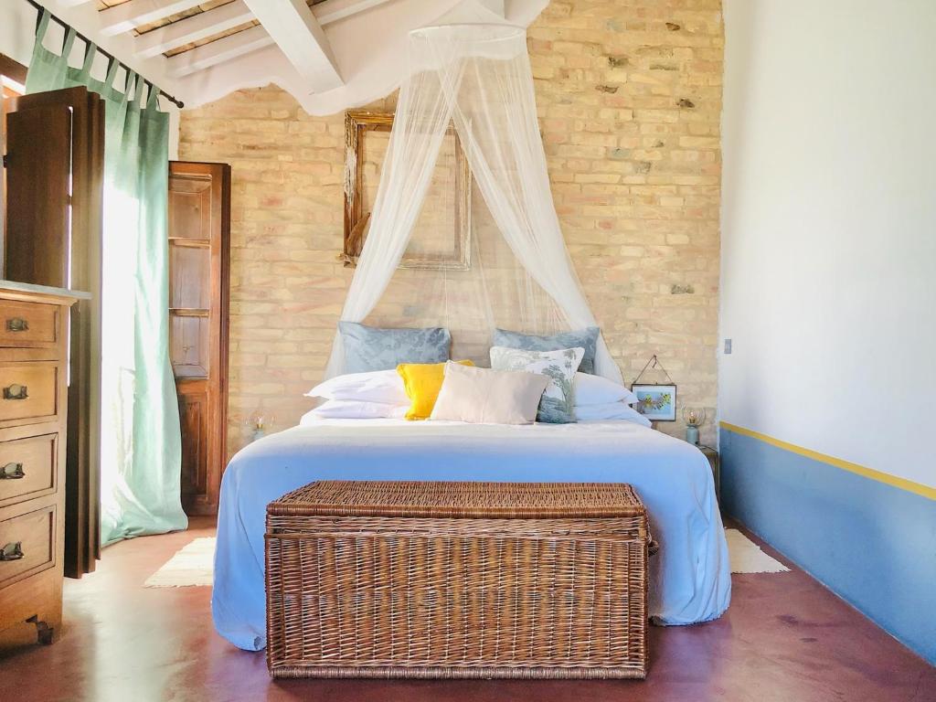 1 dormitorio con 1 cama grande y un baúl de mimbre en Effimera - Relaxing Retreat, en Citta' Sant'Angelo