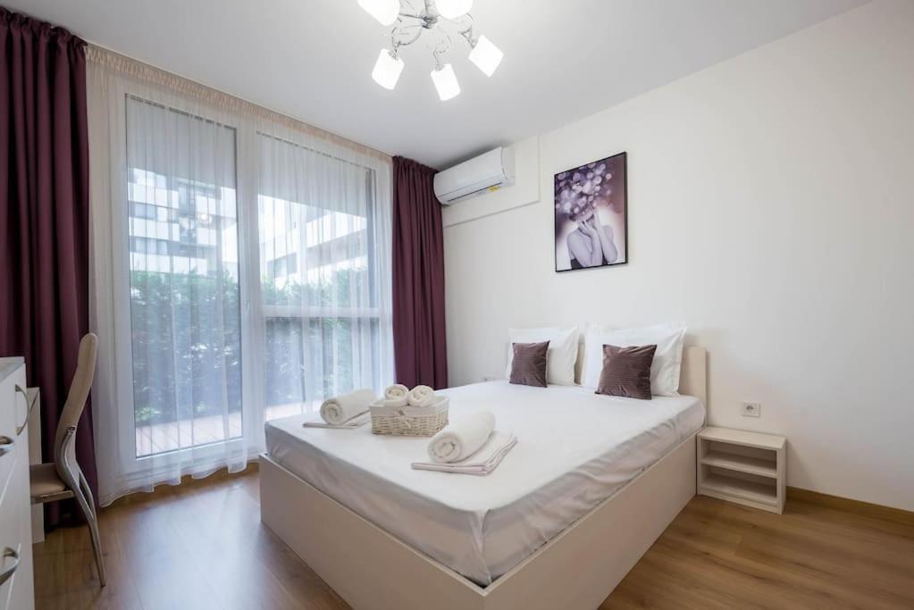 1 dormitorio con 1 cama blanca grande y ventana en Labyrinth Apartment - free parking space included, en Varna