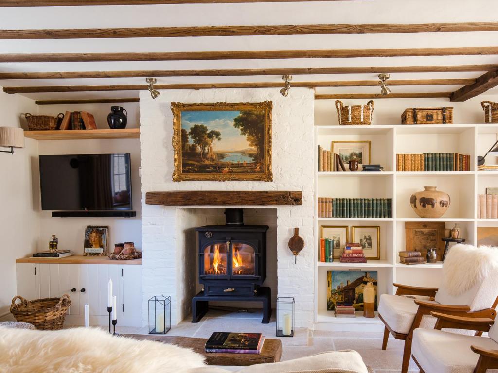 a fireplace in a living room with a fire place at Little Oakley Cottage in Sandford Saint Martin