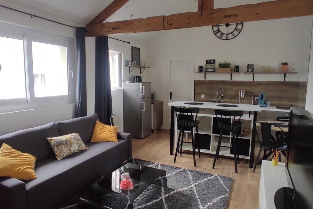 uma sala de estar com um sofá e uma cozinha em Tendance et Charmant F2 em Le Havre