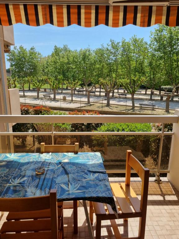 a table and chairs on a balcony with a view of a park at studio cabine. Terrasse in Le Lavandou