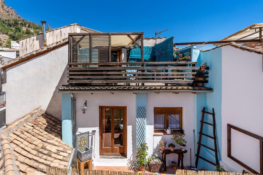 uma casa com uma varanda em cima em La lechuga azul em Güéjar-Sierra