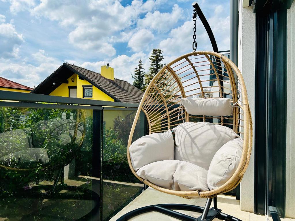 une chaise en rotin assise sur un balcon avec fenêtre dans l'établissement Modern - Free Parking - Balcony, à Vienne