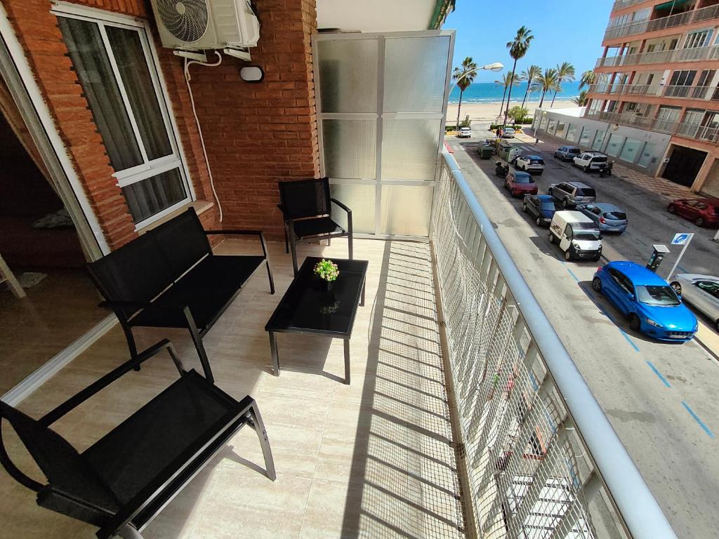 a balcony with chairs and a view of a street at Sea view apartment in Cullera