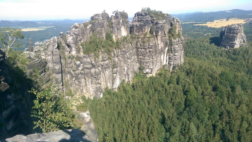 een grote rotsachtige berg met bomen ervoor bij Ferienwohnung am Kurpark Ostrau in Bad Schandau