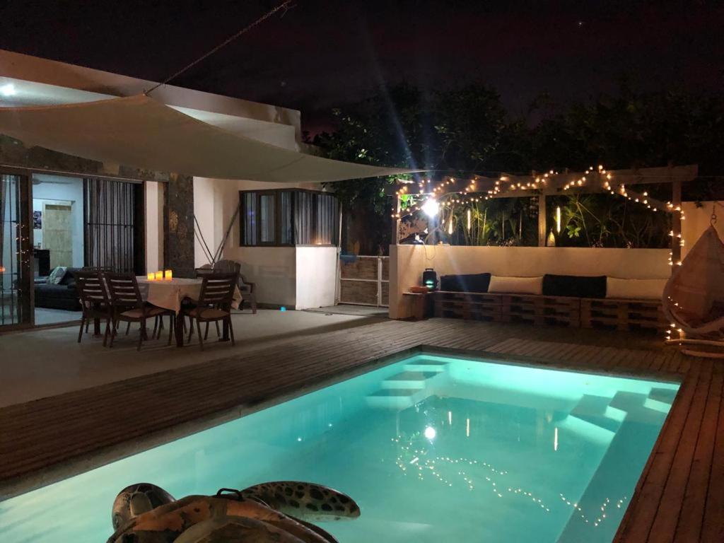 a swimming pool at night with a table and chairs at Amalfi Villa in Grand Baie