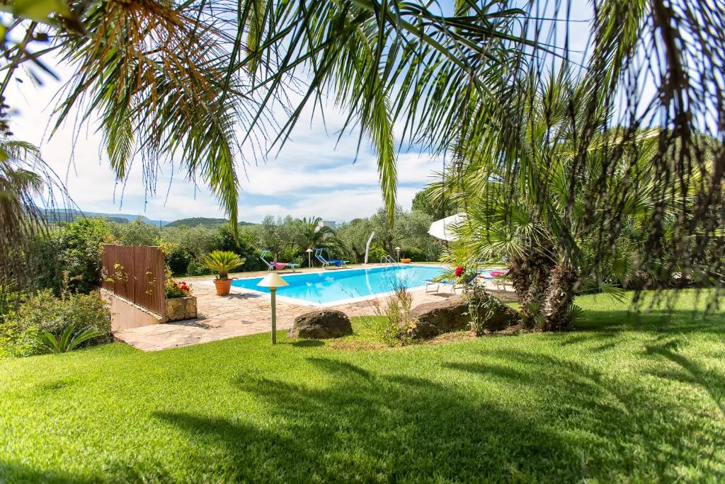 a swimming pool in a yard with a palm tree at Villa Luna Smeralda ad Alghero villa con piscina ad uso esclusivo per 8 persone in Alghero