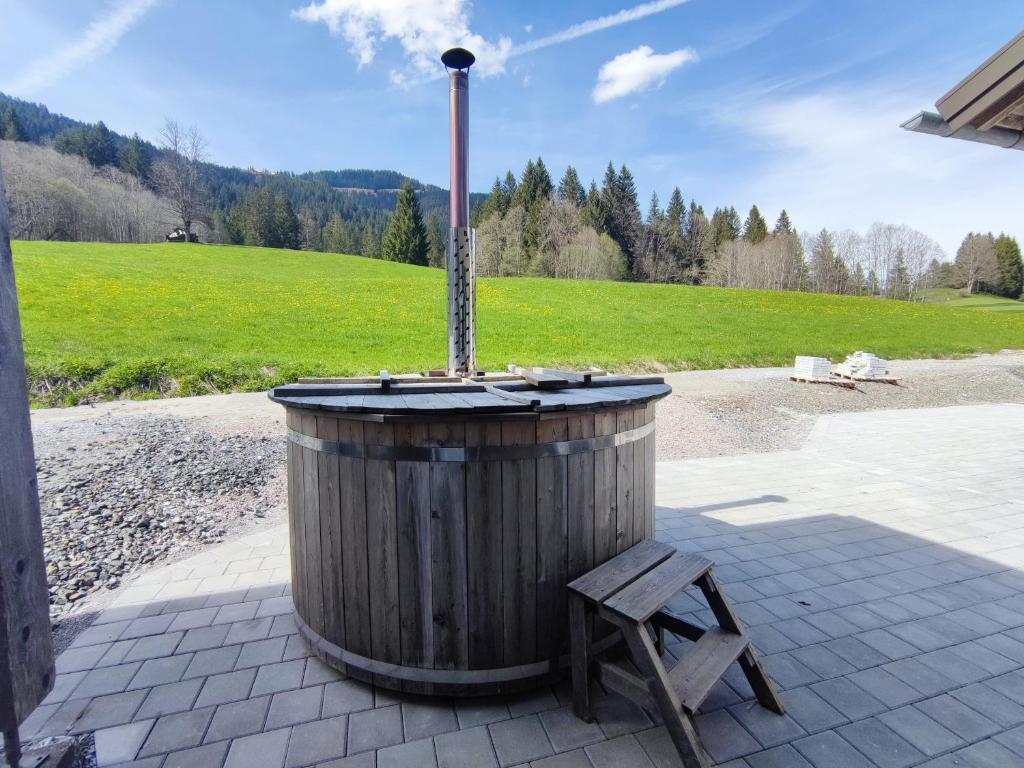 a wooden barrel with a pole and a wooden chair at Zum Hüttenklaus - 12 Personen Gruppenunterkunft in den Bergen mit eigenem Badezuber in Bad Hindelang
