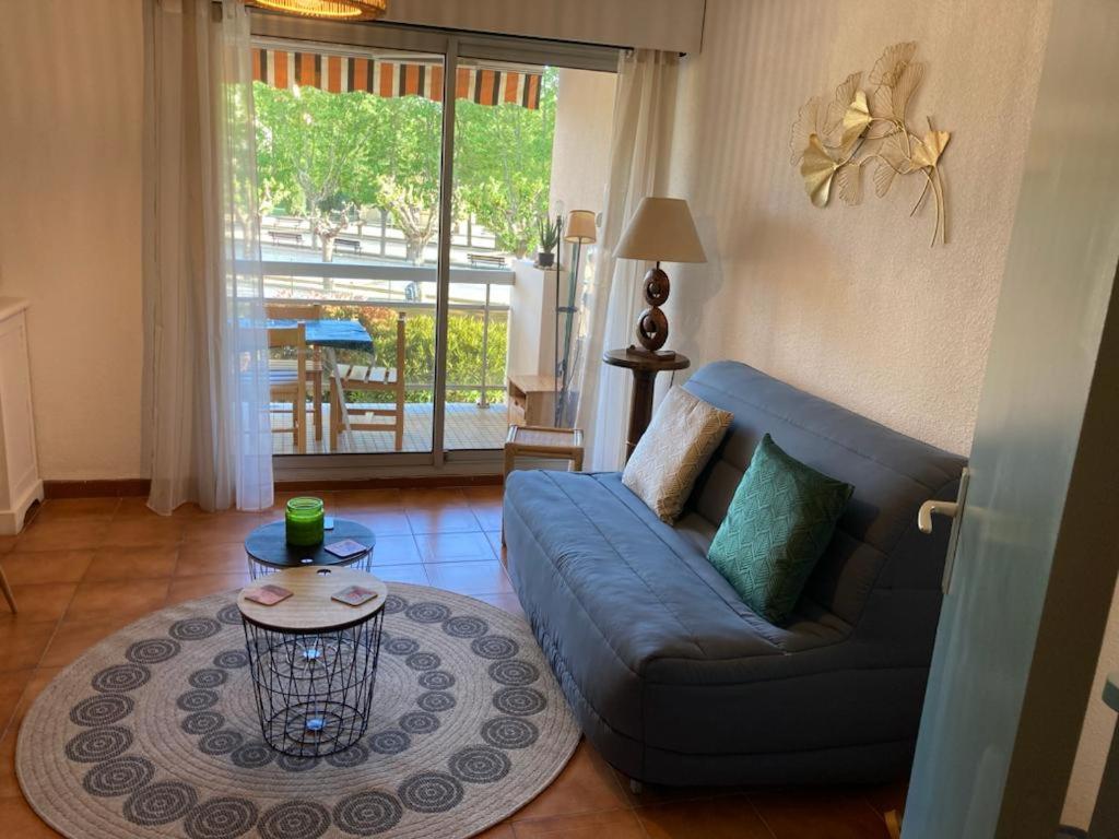 salon z niebieską kanapą i stołem w obiekcie studio cabine. Terrasse w mieście Le Lavandou