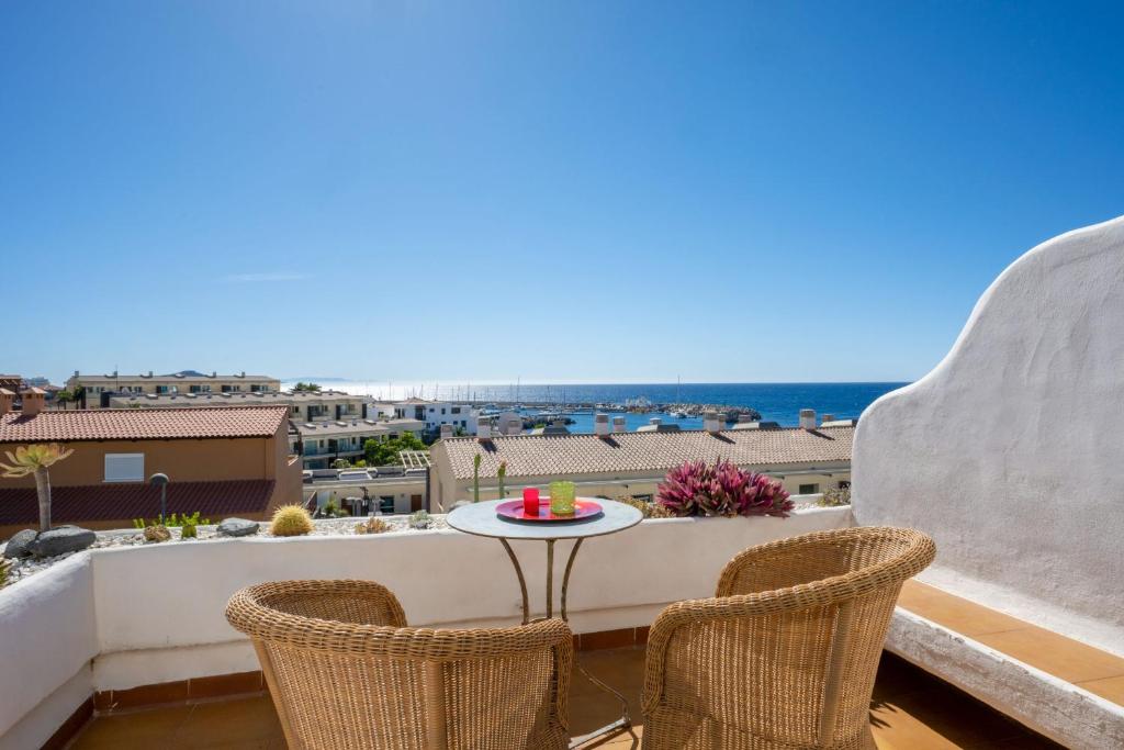 a balcony with a table and chairs and the ocean at Irina Beach Apartment in San Miguel de Abona