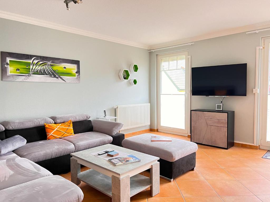 - un salon avec un canapé et une télévision dans l'établissement Haus Elaine App. 19, à Westerland