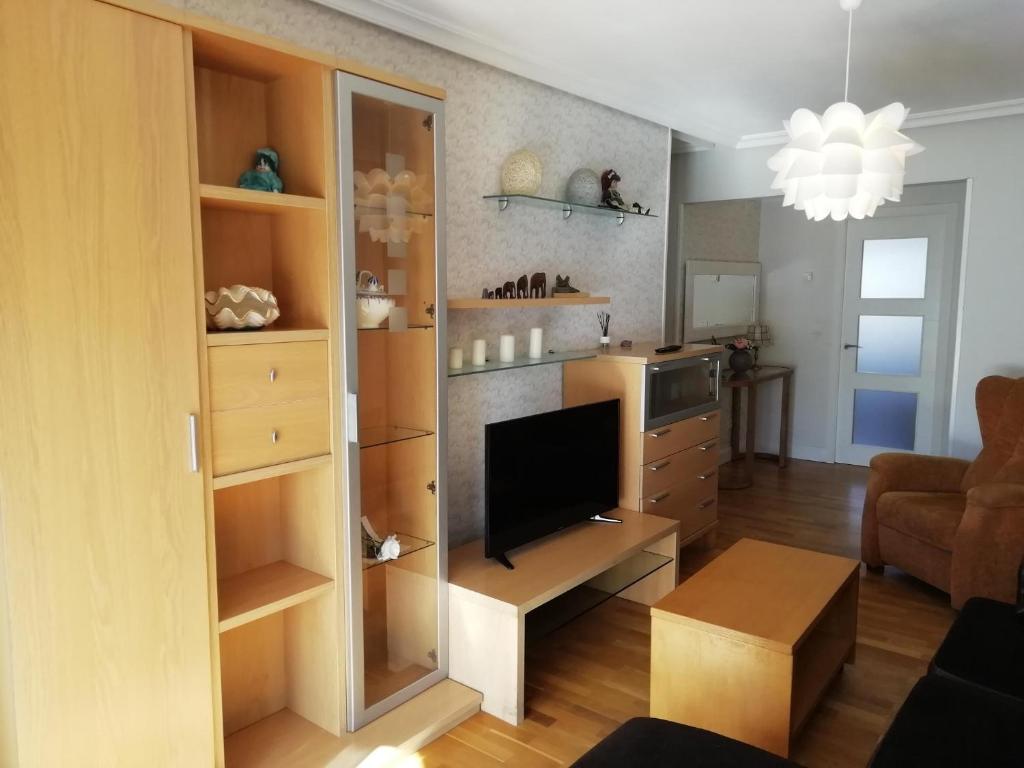 een woonkamer met een flatscreen-tv en een woonkamer bij Amplio y soleado Alquilo apartamento entero de 3 hab 5 pax in Zarautz