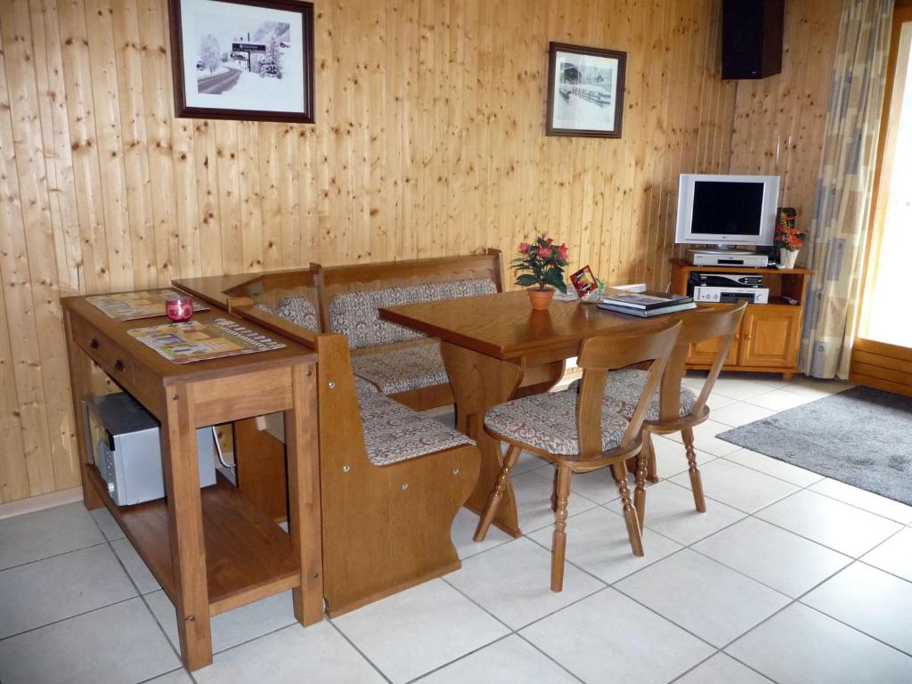 ein Wohnzimmer mit einem Holztisch und einem Schreibtisch in der Unterkunft Two Bedroom Apartement Belle Vue in La Chapelle-dʼAbondance