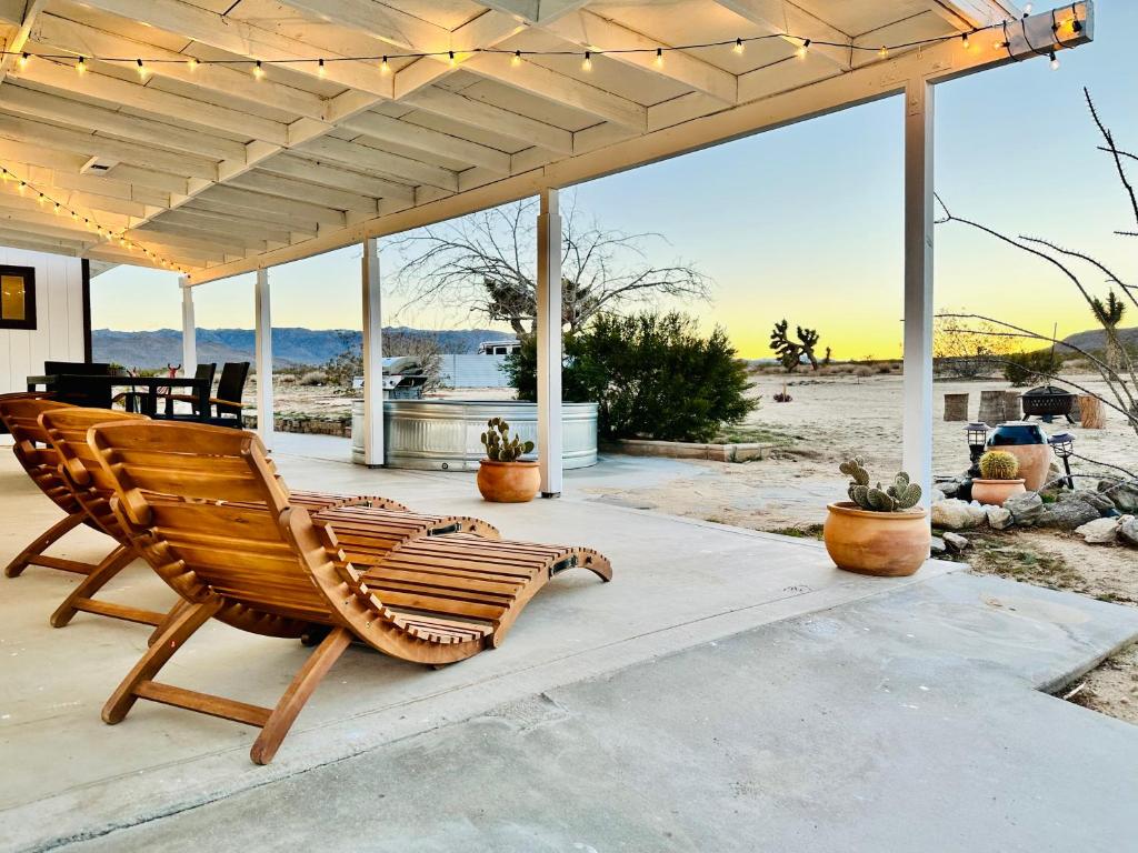 a wooden bench on a patio with a view of the beach at Ravens Nest Ranch, Fire pit , Views, Near JT Park! in Joshua Tree