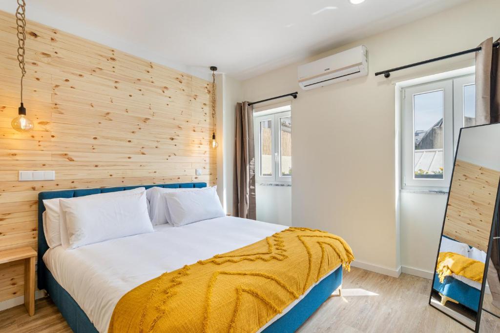 um quarto com uma cama e uma parede de madeira em Sé Apartamentos - Liberdade 546 Apartments em Braga