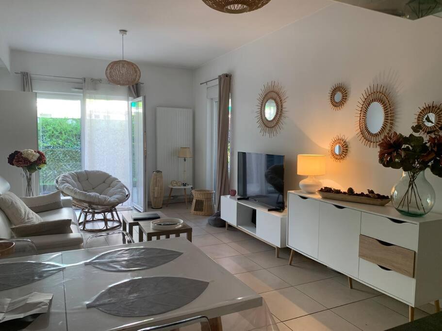 sala de estar con sofá y TV en Jolie T2 en rez-de-jardin a 150m du lac, en Aix-les-Bains