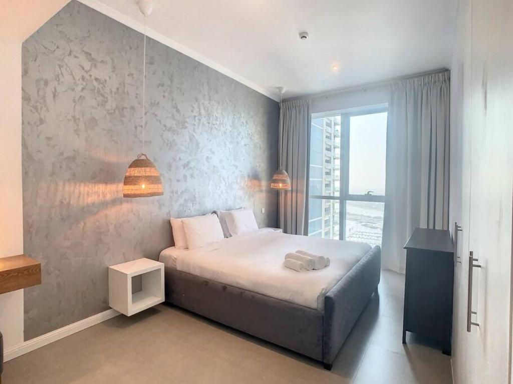um quarto com uma cama e uma grande janela em Key View - Torch Tower em Dubai