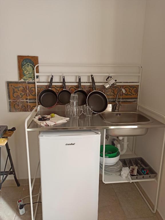 a kitchen with a sink and pots and pans at Casa cara al porto n. 26 in Bari