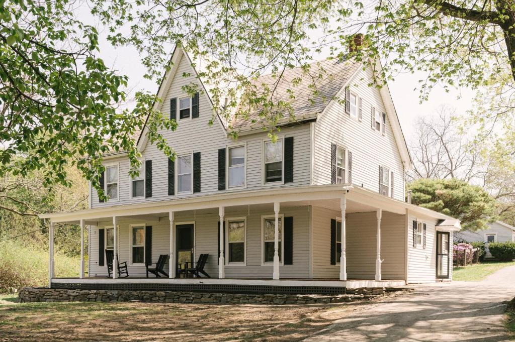 Una vieja casa blanca con persianas negras. en The Farmhouse at Glenwood Retreats, 