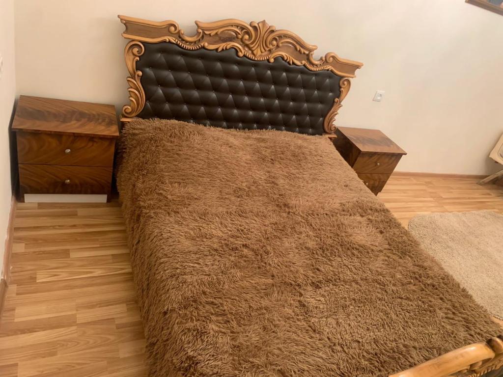 a bedroom with a large bed with a wooden headboard at Shirakatsi Guest House in Gyumri