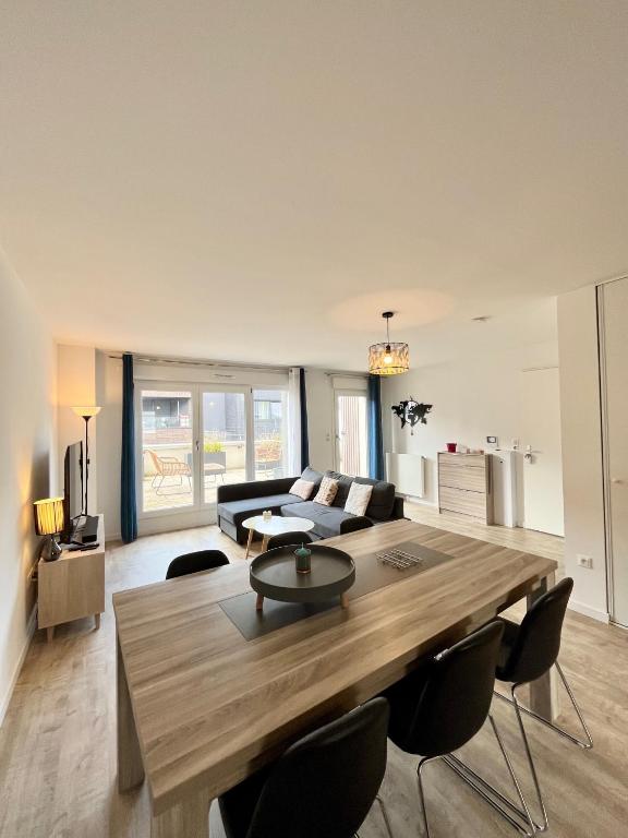 - un salon avec une grande table et des chaises en bois dans l'établissement Amsterdam - Bel appartement, à Bezannes