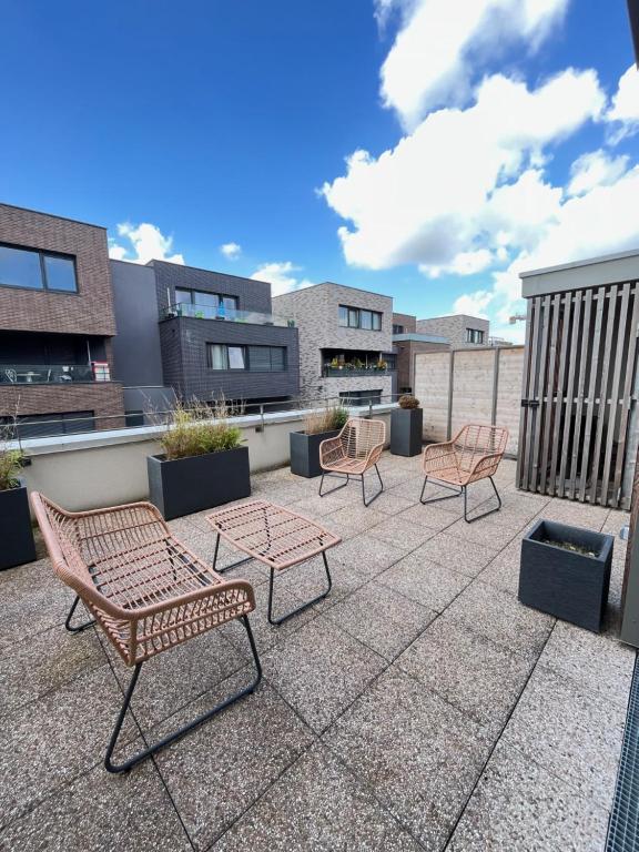 a patio with chairs and tables on a roof at Amsterdam - Bel appartement in Bezannes-les-Reims