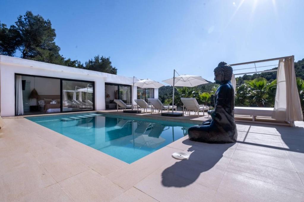 una estatua de una mujer sentada junto a una piscina en Villa Romeo en Ibiza