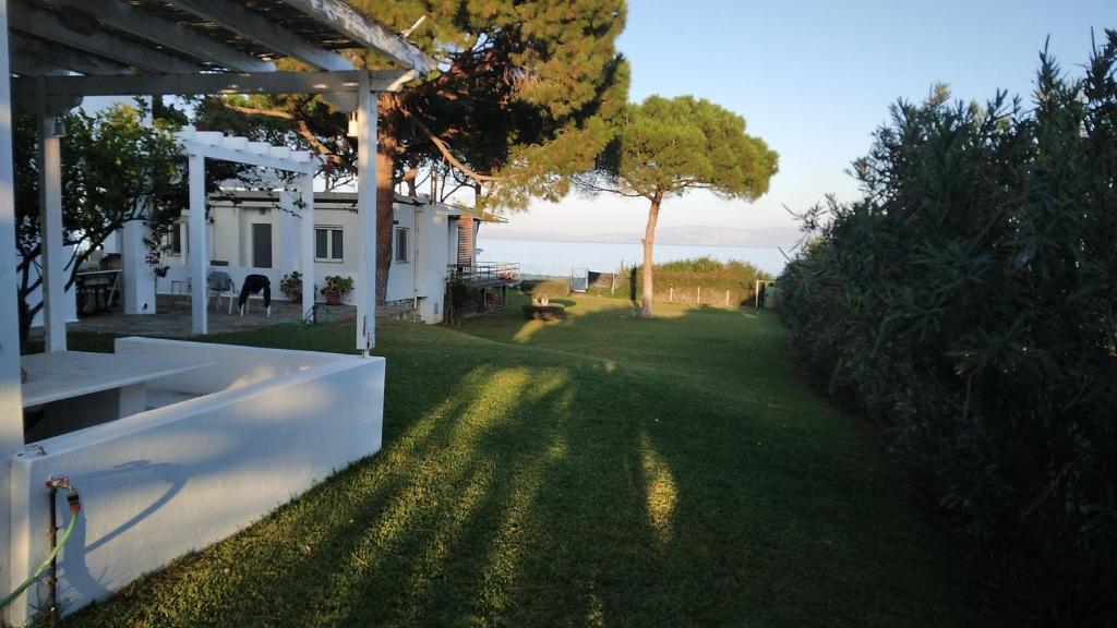 a yard of a house with a view of the ocean at House on the beach G&M in Nea Makri