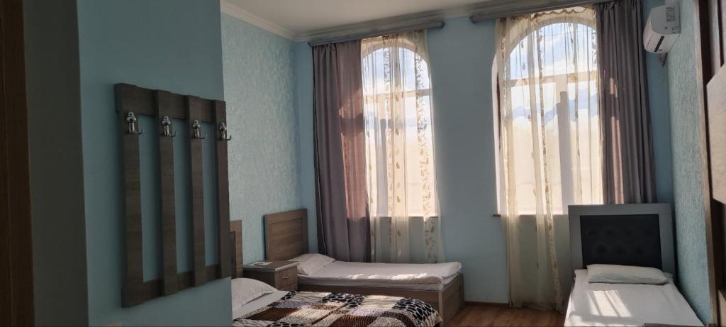 Habitación pequeña con 2 camas y 2 ventanas en Mirage guesthouse, en Khot