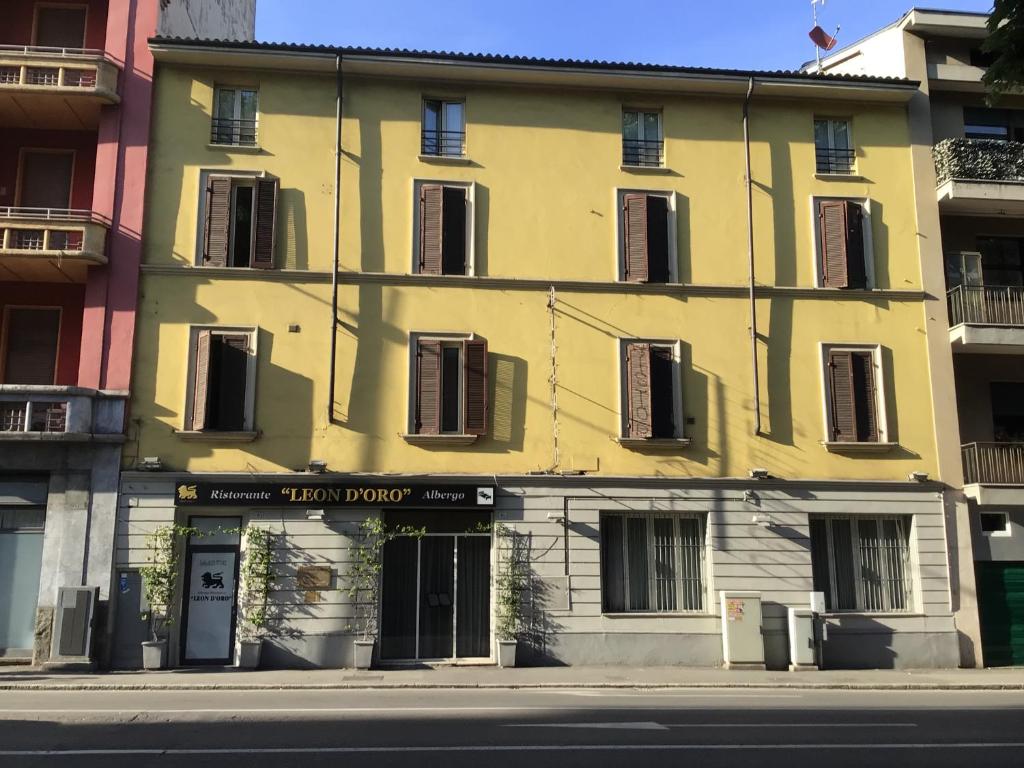 un edificio giallo con un cartello davanti di Leon doro a Parma