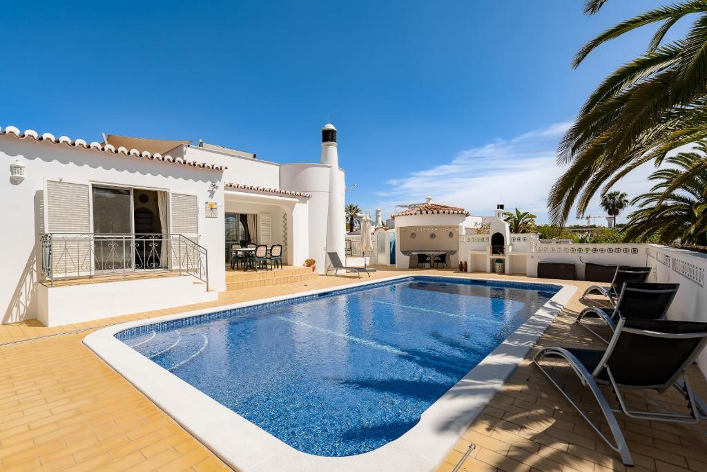 a swimming pool in front of a house at Casa Pitanga in Carvoeiro