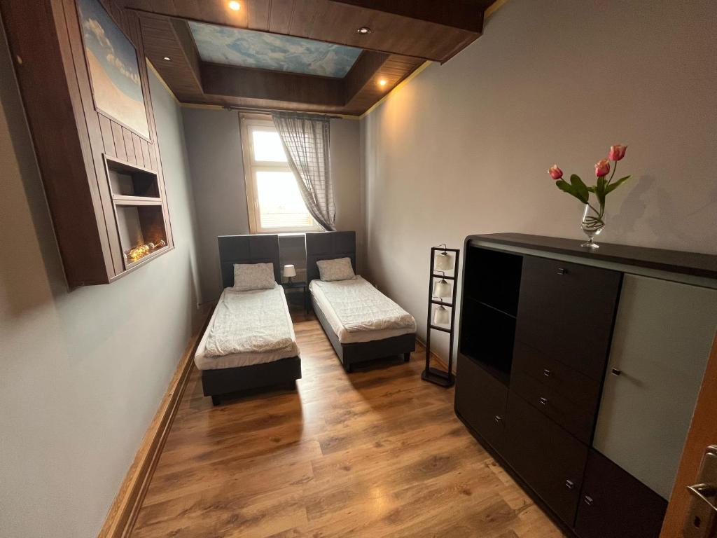 ein Wohnzimmer mit 2 Betten und einem Fenster in der Unterkunft Apartament Centrum-Zwycięstwa in Gliwice