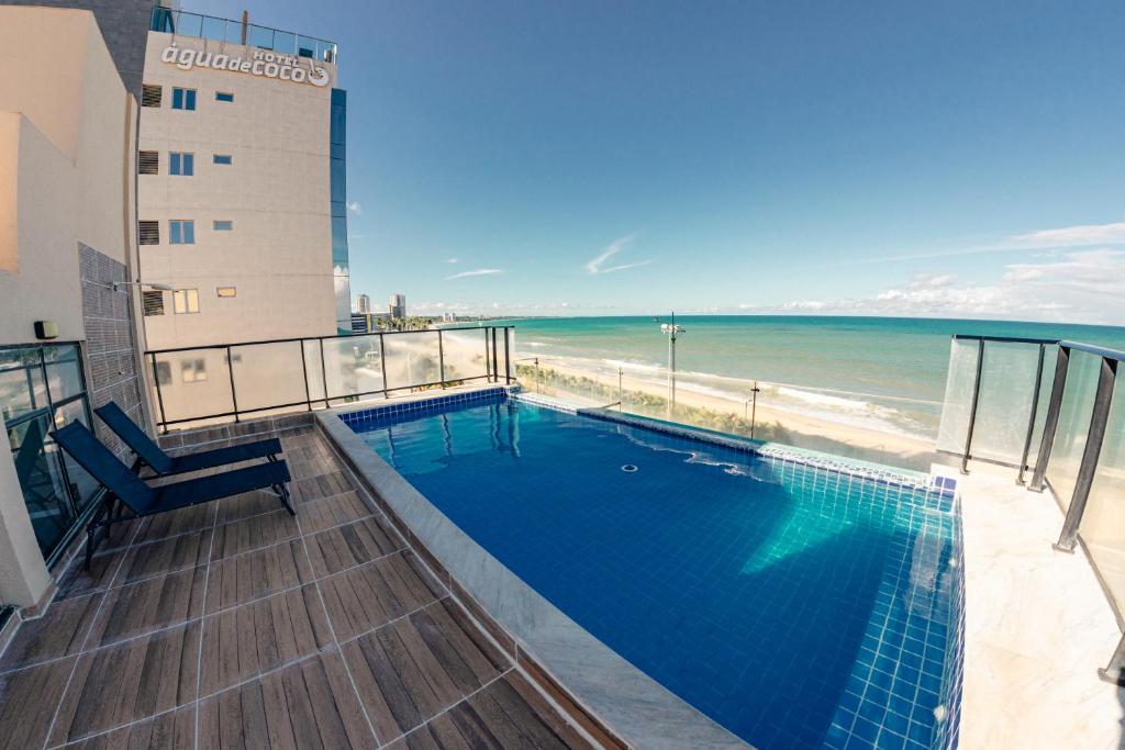 a swimming pool on top of a building next to the beach at Pousada Água de Coco in Maceió