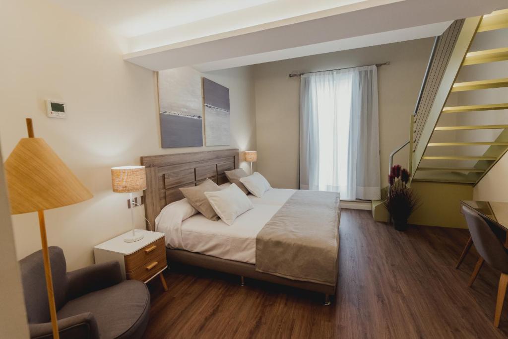 a hotel room with a bed and a staircase at Olivae Hostal Boutique in Cáceres