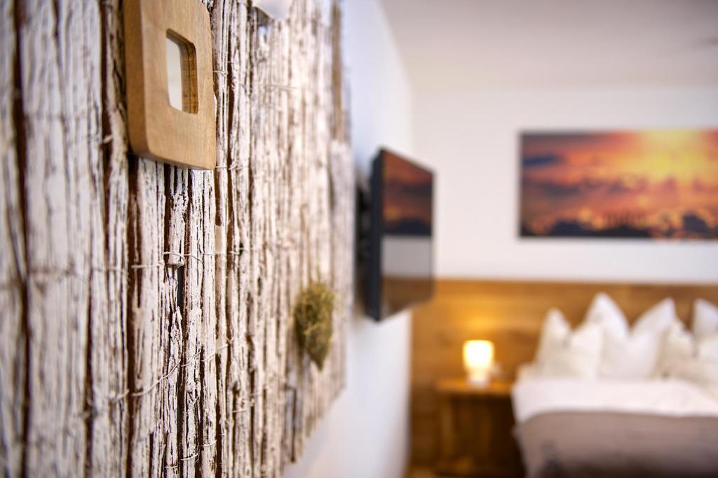 eine Wand in einem Hotelzimmer mit einem Bett in der Unterkunft Doppelzimmer Allgäuer Stub'n in Oberstaufen