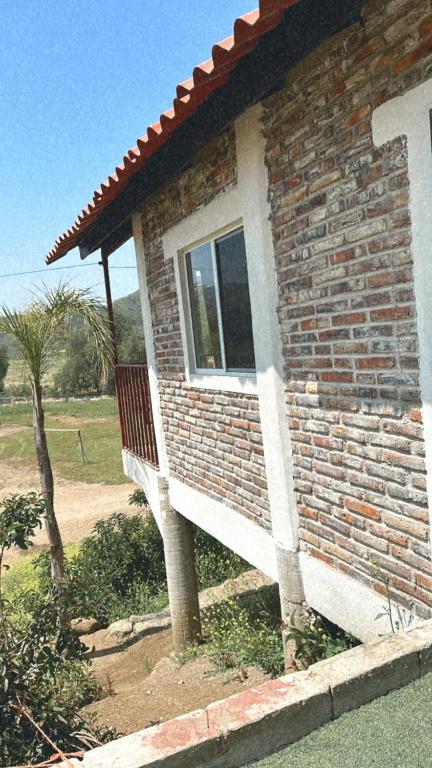 a brick house with a bench on the side of it at Cabaña en Rancho los reyes in Tijuana