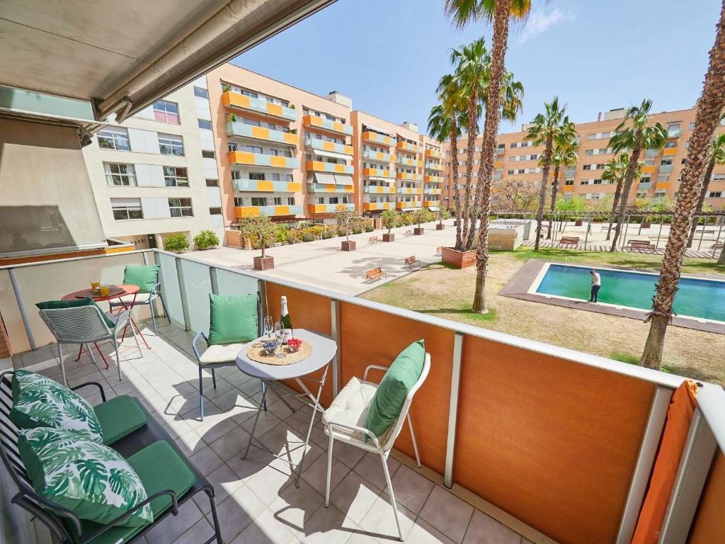 バルセロナにあるBarcelonaforrent Vila Olimpica Pool Suitesのバルコニー(椅子、テーブル、プール付)