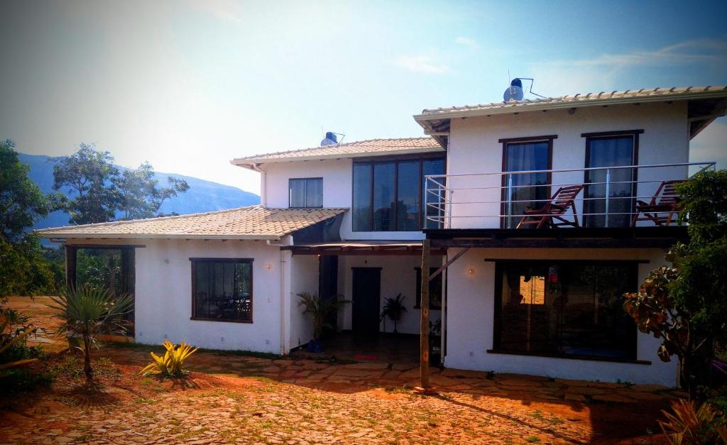 a white house with a balcony on top of it at Aldeia da Serra Lapinha in Santana do Riacho