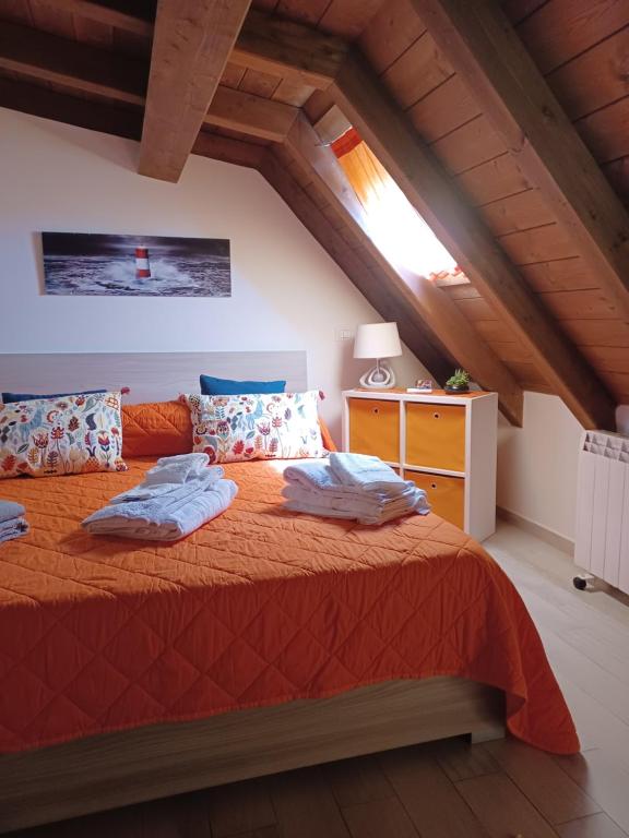 een slaapkamer met een bed met een oranje sprei bij Appartamento Fiuggi Terme in Fiuggi