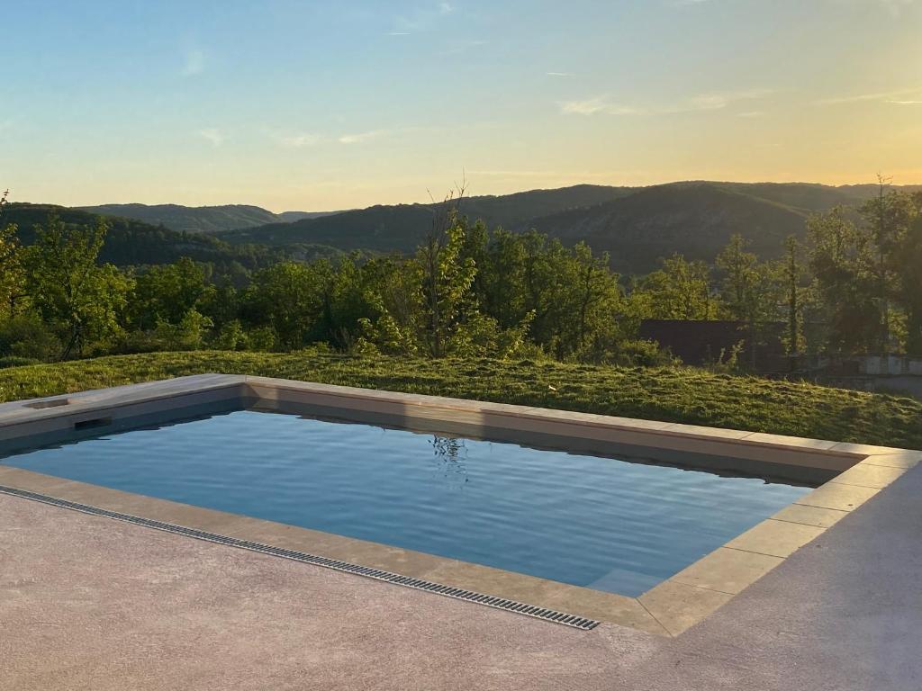 a swimming pool with a view of the mountains at Vacances Vallée de la Dordogne in Souillac