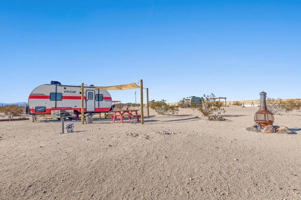 een camper geparkeerd in het midden van de woestijn bij JT Village Campground - Sun Ray in Joshua Tree