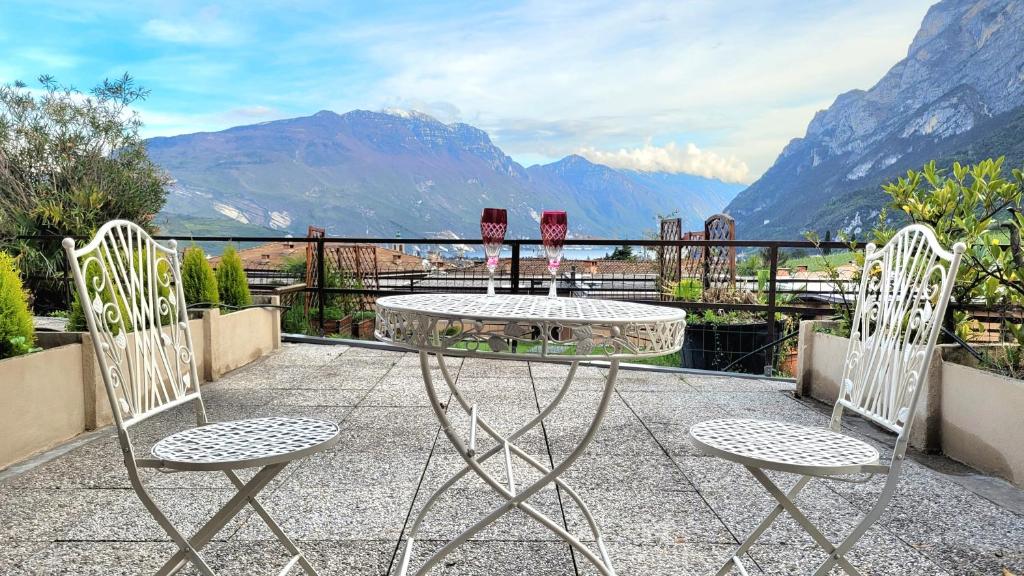2 Stühle und ein Tisch auf einem Balkon mit Bergblick in der Unterkunft appartamento PEACE&LAKE in Riva del Garda