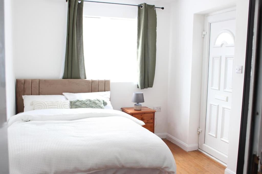 a bedroom with a large white bed with a window at Self-contained guest suite in Eltham
