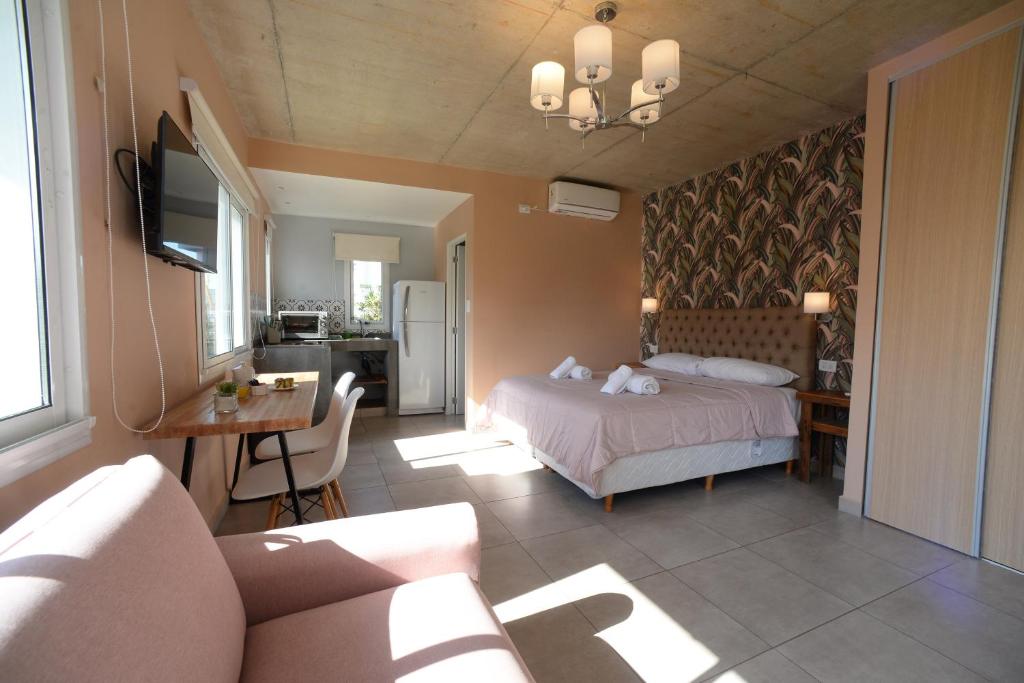 un dormitorio con una cama y una mesa y un sofá en La Morada Apart Boutique & Spa en Villa Gesell