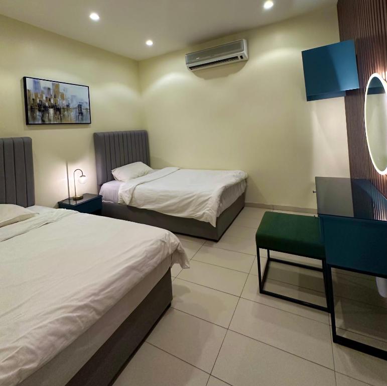 una camera d'albergo con due letti e uno specchio di شاليهات كابري وماديرا درة العروس a Durat Alarous