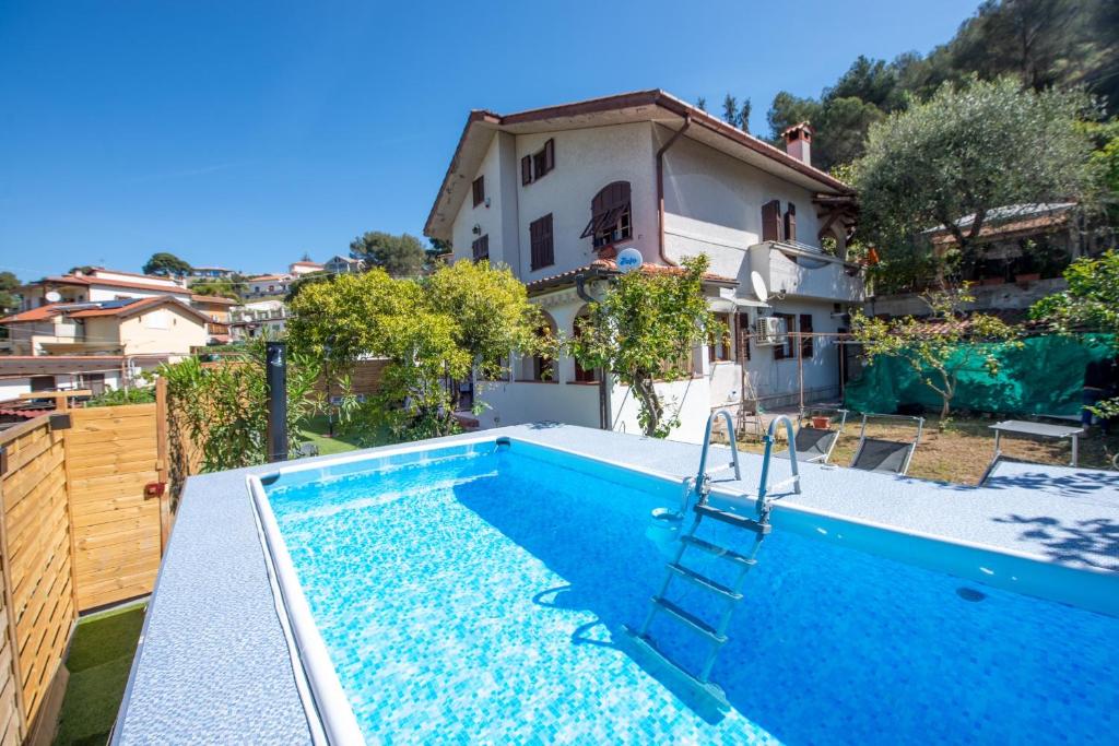 a swimming pool in front of a house at Casa del Sole: Relax & Charme nella Riviera Ligure in Camporosso