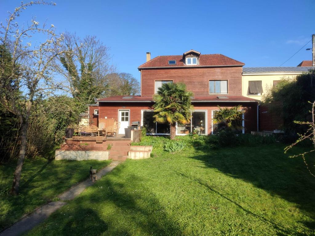 une grande maison en briques avec une cour d'herbe dans l'établissement Rouen, à Rouen