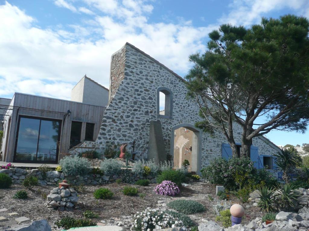 a stone house with a garden in front of it at Domaine Castelsec in Roquefort-des-Corbières