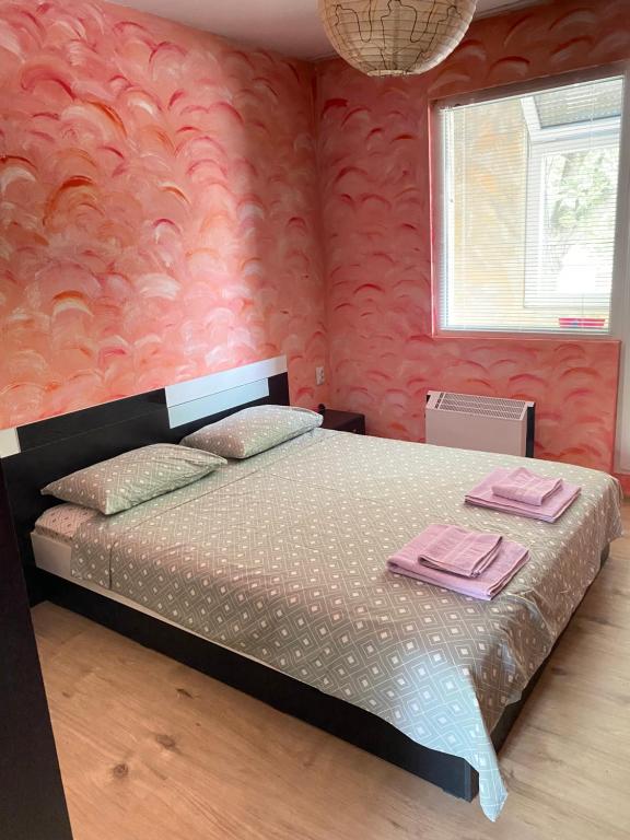 ルセにあるАПАРТАМЕНТ МИДИЯ ЕНОС РУСЕのピンクの壁のベッドルーム1室